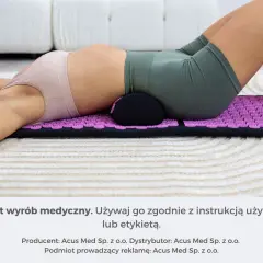 Kobieta leży na macie do akupresury, która wspiera jej odcinek lędźwiowy. To pokazuje, jak działa mata, stymulując punkty nacisku.