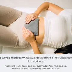 Kobieta z termoforem na brzuchu. Pamiętaj o instrukcji, by uniknąć skutków ubocznych termoforu.