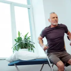 Starszy mężczyzna z kulami ćwiczy po operacji biodra. Ważne jest, jak długo należy uważać po operacji biodra.