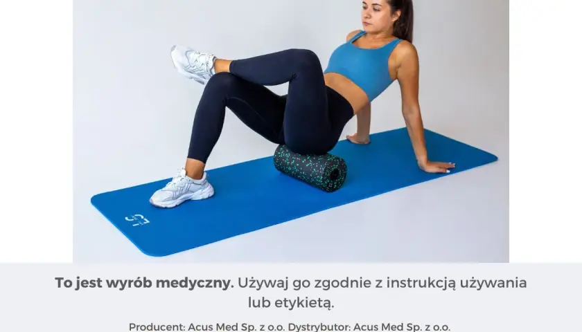 Kobieta na macie rehabilitacyjnej demonstruje, jak masować mięsień gruszkowaty za pomocą rollera.