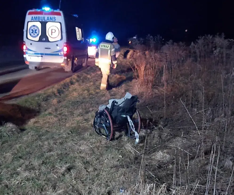 osoba na wózku inwalidzkim z odblaskami po zmroku