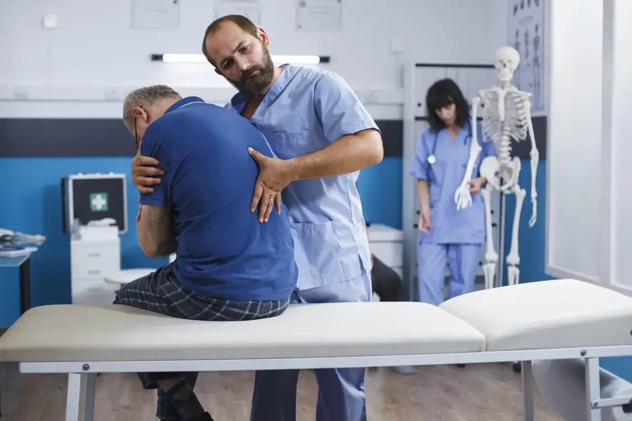 Fizjoterapeuta bada plecy pacjenta. Zastanawiasz się, ile trwa wizyta u fizjoterapeuty? Zazwyczaj od 30 do 60 minut.